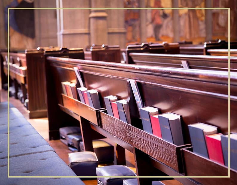 A row of pews with books in them.