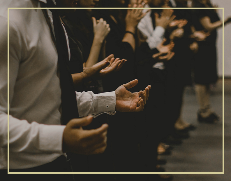 A group of people clapping with their hands in the air.