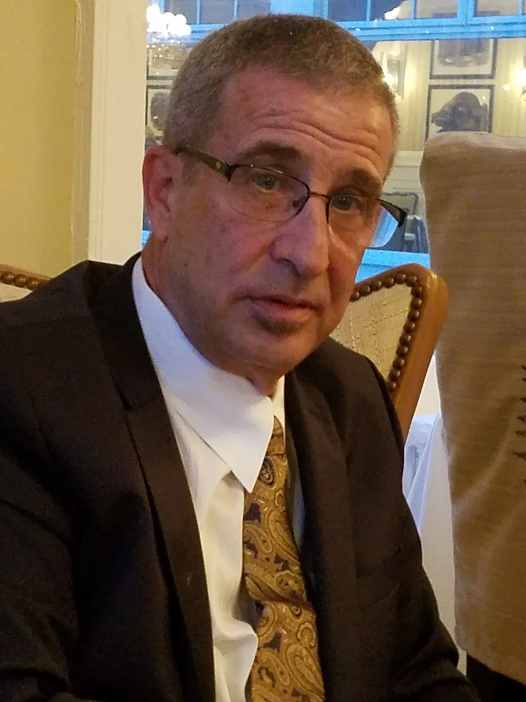 A man in a suit and tie sitting down.